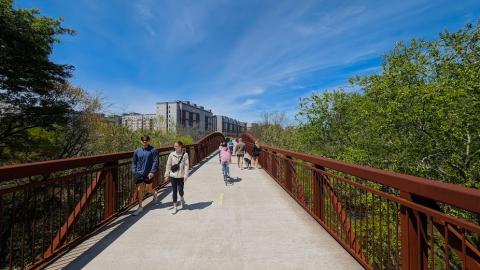 A photo of a long bike pathway under blue skies next to many trees in Athens Georgia. 