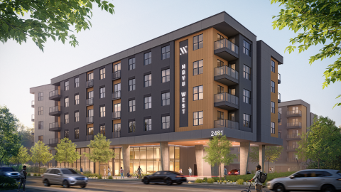 An image showing a site where a large apartment project is proposed under blue skies with a gray and orange facade and many balconies.