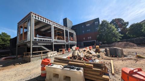 A photo of a large brick building being expanded and redone under blue skies next to a gray building in Atlanta.