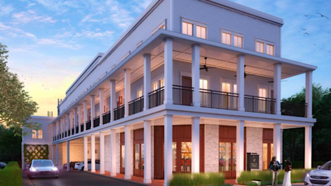 An image of a small white new townhome building taking shape in downtown Athens Georgia with big porches and parking in back. 