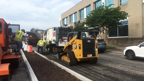 A photo of construction crews installing new medians and resurfacing a busy road in Atlanta. 