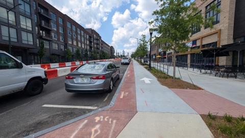 A photo showing a road in Atlanta with much construction for bus rapid transit lanes in the middle surrounded by new shops and apartments.