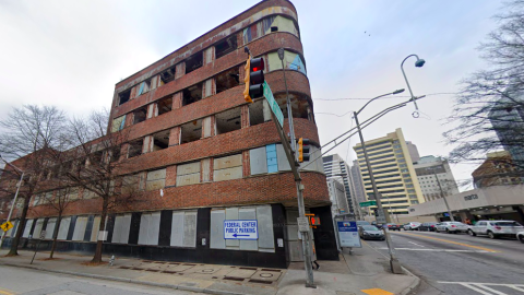 A photo of an old brick building with a curved front poised for redevelopment in downtown Atlanta with railroad gulches around it.