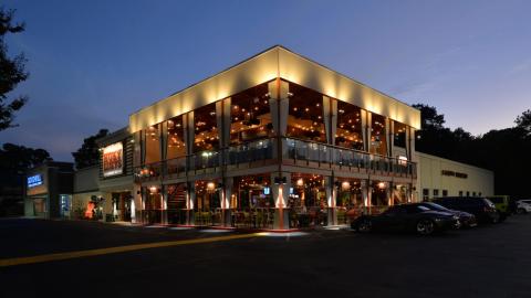 A photo of a two-level former restaurant space next to a large parking lot under blue-purple skies north of Atlanta.