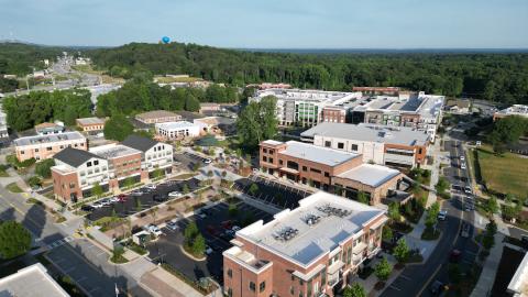 A photo showing an image of a large new town center outside Atlanta with many streets and wide roads under blue skies.