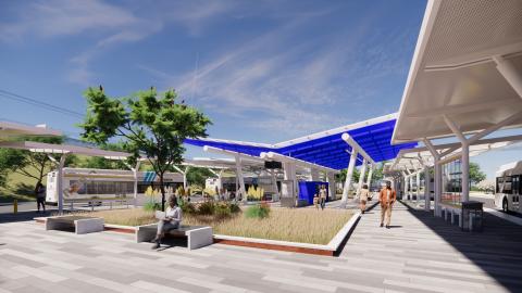 An image showing a large new bus transit hub with opening seating area and grasses under blue skies.