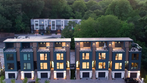 A photo of a row of new townhomes with four stories and modern exteriors and interiors near many trees in Atlanta. 