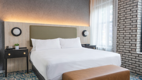 A photo of an old school style hotel room with large windows and brick walls in downtown Atlanta, near wide streets.