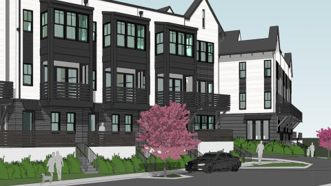 Image of a large black and white townhome development under blue skies near wide streets in Atlanta.