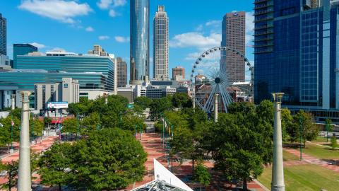 An image of a large park and ferris wheel under blue skies in downtown Atlanta. 