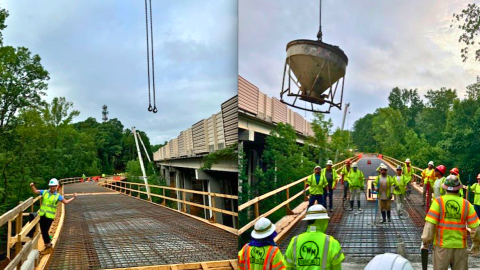 An image of a large new trail structure being built next to many trees with a large bike bridge in the middle.