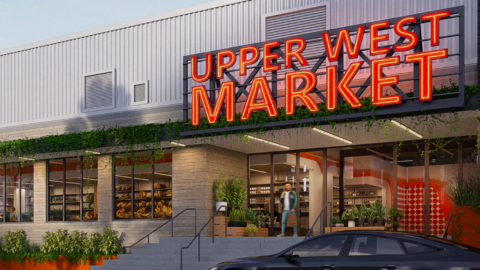 An image of a warehouse space where an indoor farmers market with a food concept is planned in a white building with a large parking lot in Atlanta.