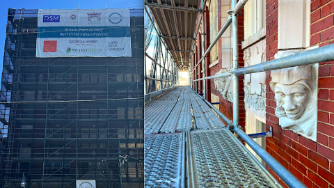 An image of a large brick historic building with scaffolding on it that's being restored in Sweet Auburn Atlanta near a wide street. 