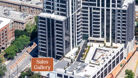 A photo of a new luxury condo tower in Buckhead Atlanta with a large pool area over a wide street with many trees around, and modern-style interiors with white cabinets. 