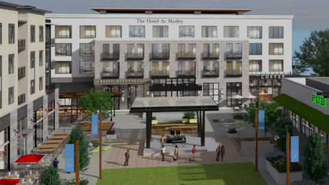 A rendering showing a large white hotel as part of a new development with a plaza and pub and outdoor seating.