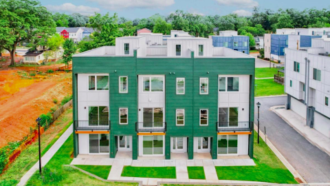 A large new townhome project next to a large construction site under blue skies in Atlanta, with white modern interiors.