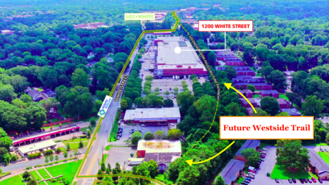 An image showing a new section of multi-use trail in Atlanta near many trees under blue-gray skies for the Beltline. 