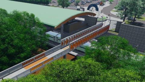 An image showing a long concrete and orange new pedestrian bridge at a MARTA station with many trees around.