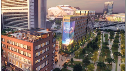 An image showing a large old brick building remade into apartments in downtown Atlanta next to a new concrete and glass building that's wedge-shaped.