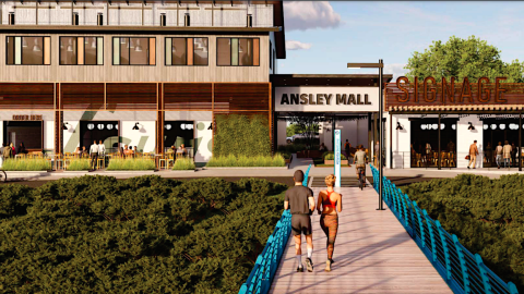 An image showing a large new pedestrian bridge over a creek with green banks and the backside of a mall transformed into a retail strip.