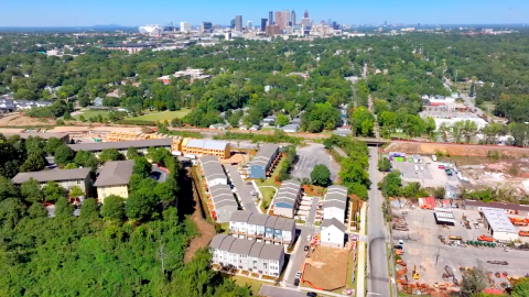 An overview of a large new townhome community in southside Atlanta near many trees and wide streets.