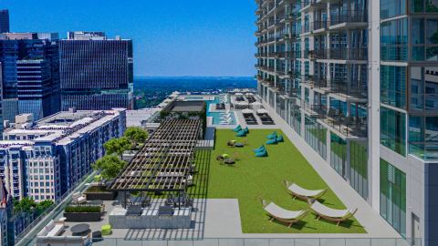 A photo of a large tall glassy new tower with modern interiors and a pool level in Midtown Atlanta under blue skies.