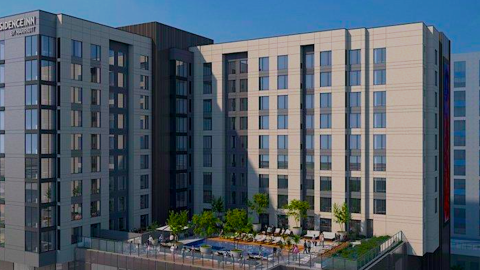 A rendering for a large hotel building under blue skies with an elevated pool in the middle near a large Atlanta park.