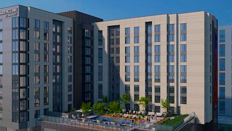 A rendering for a large hotel building under blue skies with an elevated pool in the middle near a large Atlanta park. 