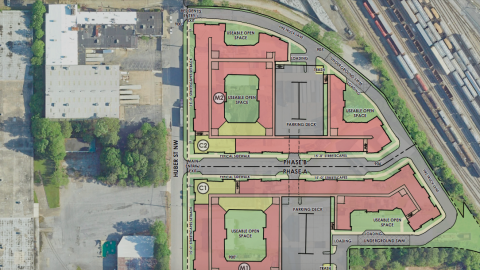 An overview of a site near a huge area of railroad tracks on the westside of Atlanta showing plans for two large apartments in doughnut-shaped buildings.