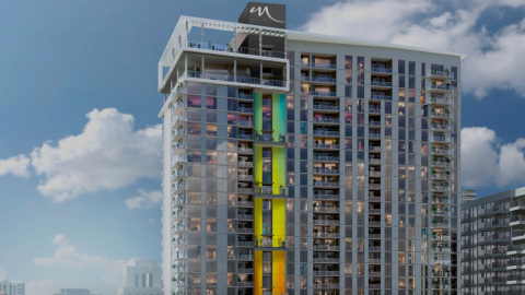 An image showing a large glassy apartment tower under blue skies in Midtown Atlanta with luxury amenities and white-walled new modern apartments.