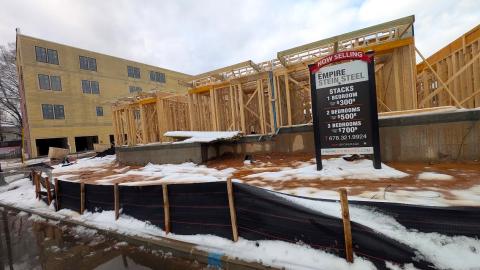 An image of a large new construction site under blue-gray clouds beside a street in Atlanta, Georgia.