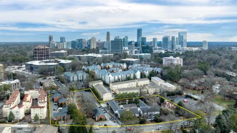 An overview of a large development site with many homes near high-rises in Buckhead Atlanta, under cloudy skies.