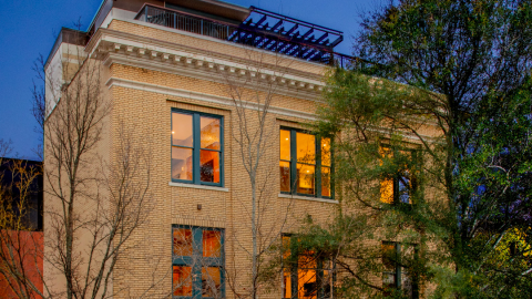 A photo of a boutique brick hotel under night skies in downtown Athens with multicolored and very well-designed rooms and bathrooms inside. 