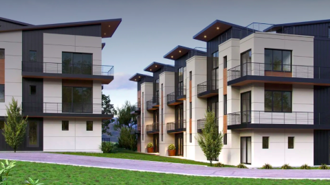 An image of a site surrounded by woods where brown and white and tan modern housing is being built on Atlanta's northeast side.