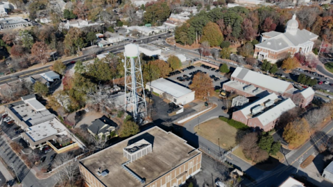 An aerial photo of a large block with many buildings in a suburban Atlanta city where development is planned, with a water tower in the middle.