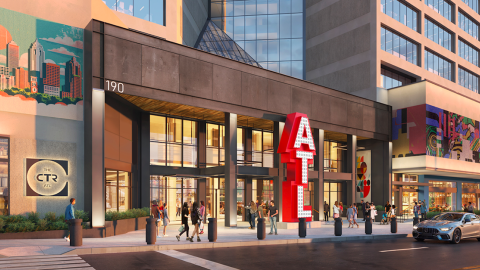 A large concrete building in a big downtown area with new signage and art and many new restaurants.