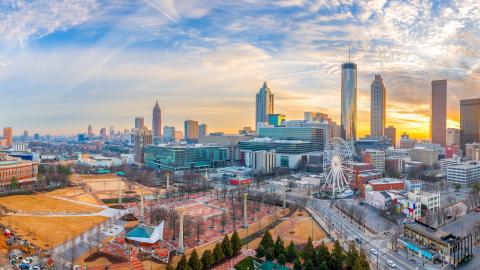 A photo showing the downtown Atlanta skyline at evening with many buildings and a large park.