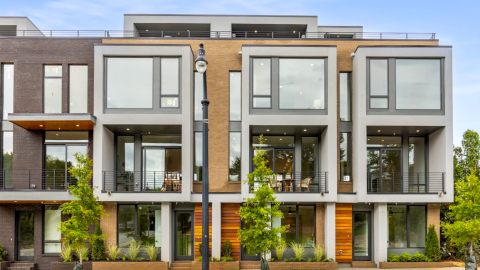 A gray wood and glass townhome project with rooftop decks under blue skies in Atlanta.