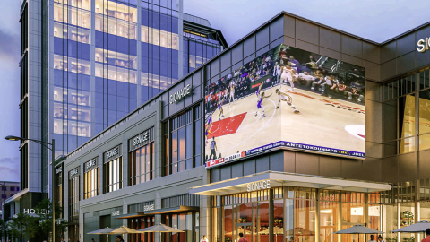A rendering showing a large new hotel and entertainment district development in downtown Atlanta under dark blue skies, near many wide streets..