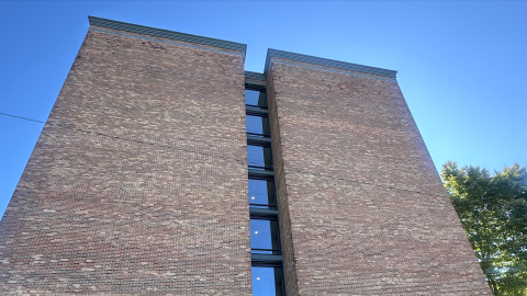 A large brick building with a blank wall under blue skies near wide streets in metro Atlanta. 