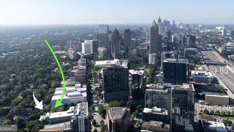 An aerial photo of a large city with a small parcel tucked among many building under a hazy blue sky in Atlanta.