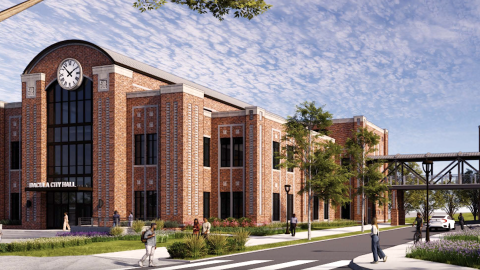 An image showing a large new site where brick building and wide streets and a parking deck near greenspaces are being building in the Atlanta suburbs.