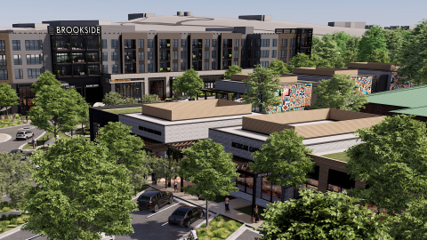 An overview of a remade office park under blue gray skies in suburban Atlanta with many shops and trees and parking spaces.
