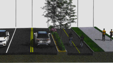 An image of a wide street that's being converted in a two-lane roadway with protected cycling and bike lanes east of Atlanta, with many trees.