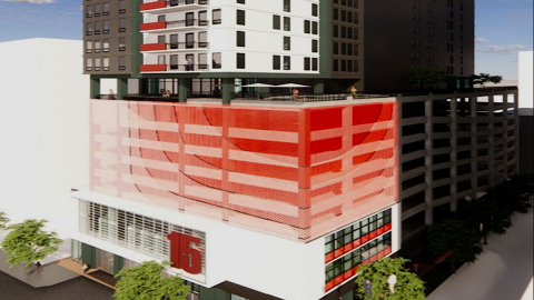 An image showing a large high-rise rendering and a development site in Atlanta under sunny skies, near wide streets.
