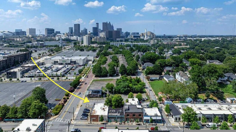 An overview of four properties for sale next to each other along two wide streets in Atlanta under blue skies. 
