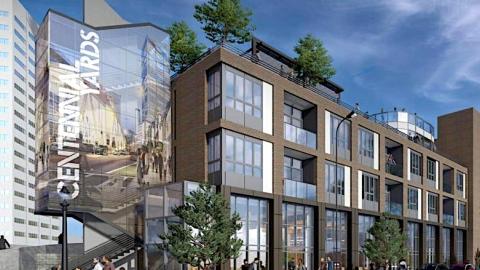 A rendering showing a new brick and glass-clad hotel under blue skies with a patio in downtown Atlanta.