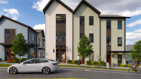 An image showing a site where modern-style tall townhomes with blue, white, and light green facades are being built in Atlanta under blue skies, near the Beltline Trail.
