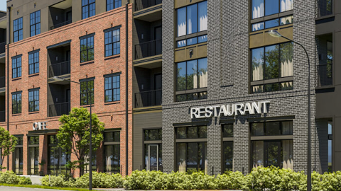 A rendering of a large new brick and black apartment community in Hapeville south of Atlanta under blue skies, near wide streets and an airport. 
