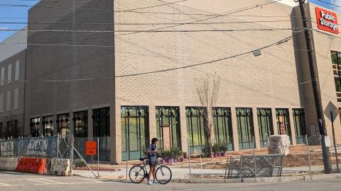 A photo of a huge bland brick storage building under blue skies near wide street and trees in Atlanta. 